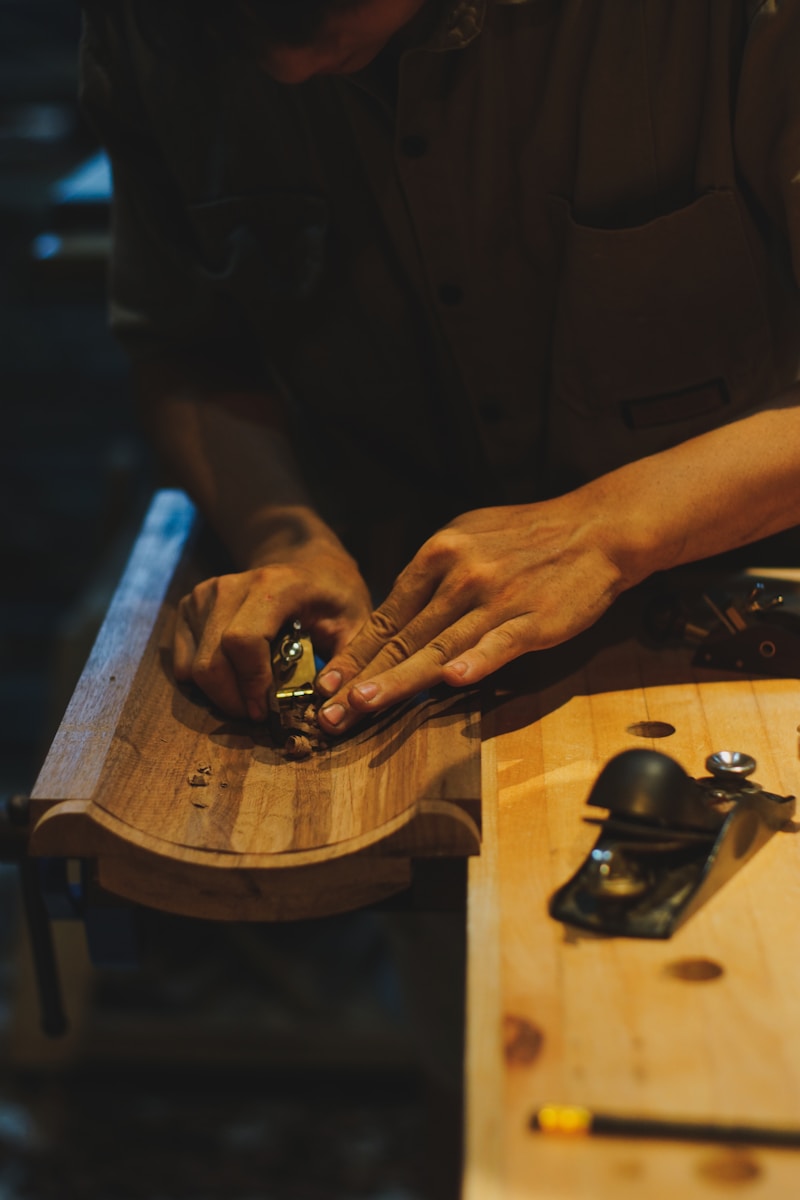 Master Tuscan artisan handcrafting solid walnut furniture at the workbench in Cascina
