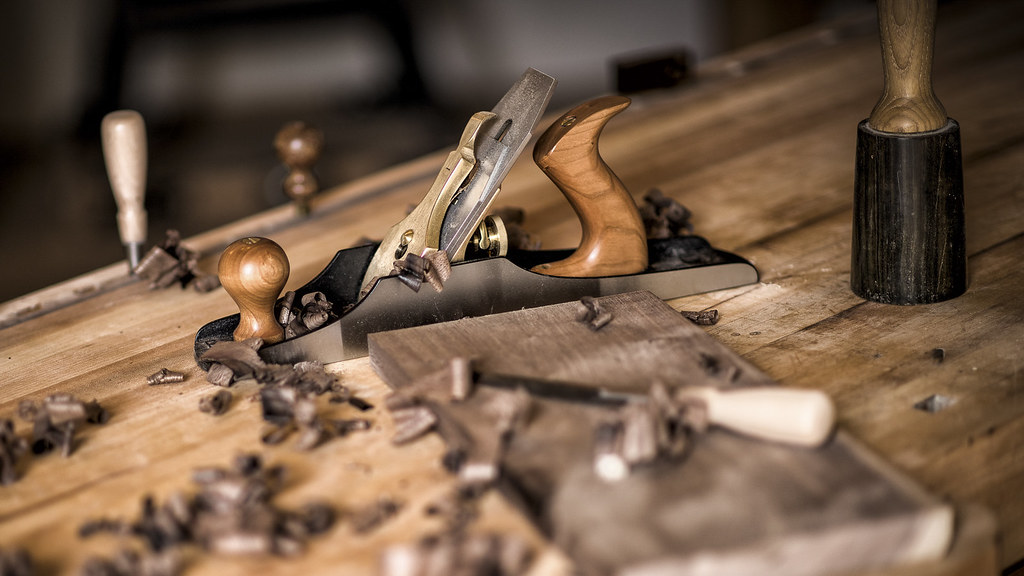 Wooden hand plane and shavings on the bench in the Cascina workshop